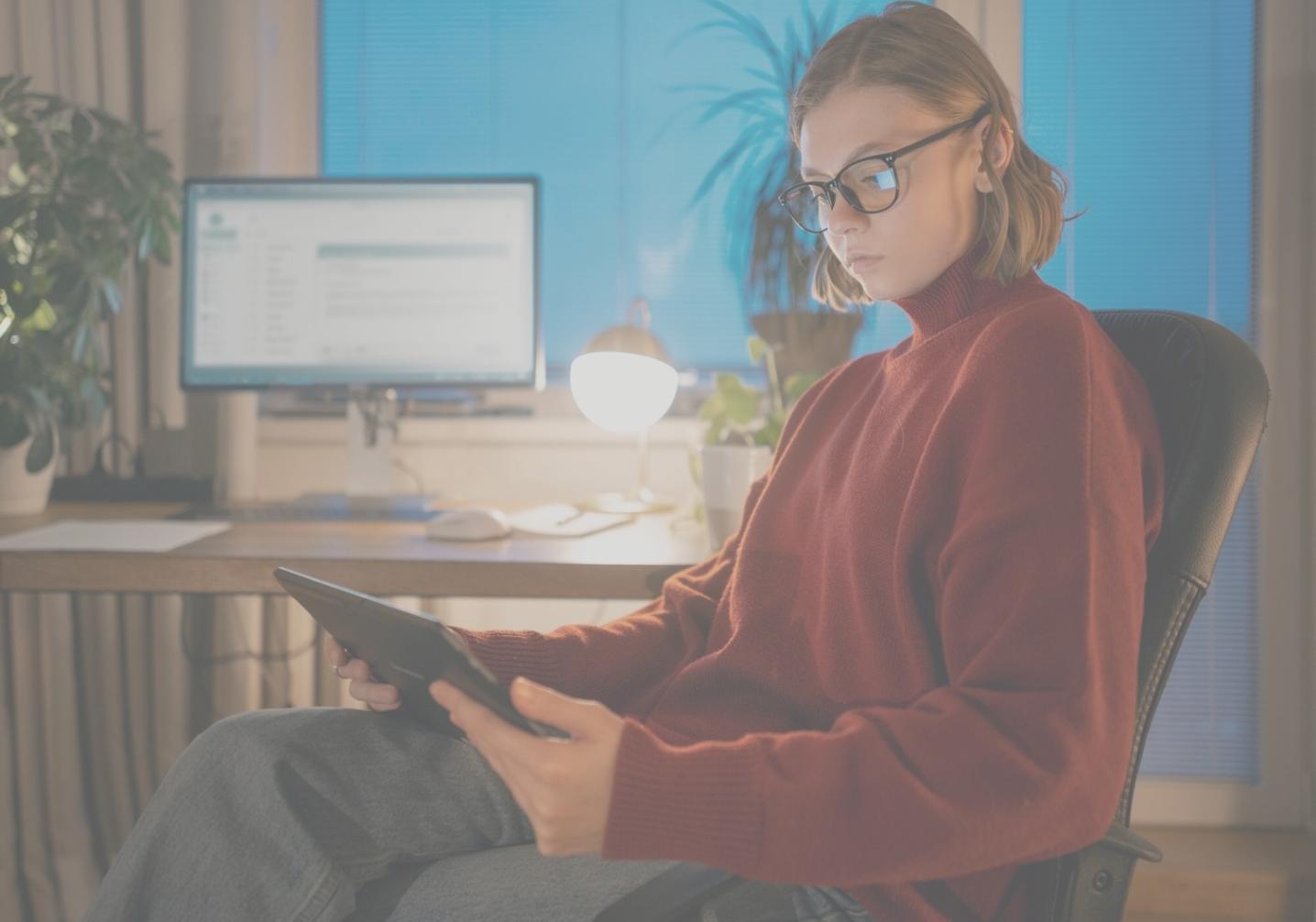 Estudiante trabajando en análisis financiero con múltiples pantallas mostrando gráficos y datos